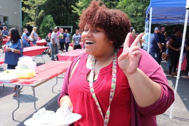 Woman giving peace sign at event